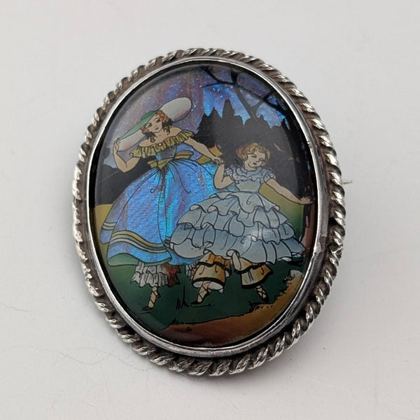 Vintage British sterling silver oval brooch featuring two women with butterfly wings